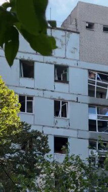 A damaged residential building with burnt-out balconies after shelling or fire. Broken windows and collapsed balcony structures are visible, the consequences of a conflict of damage.
