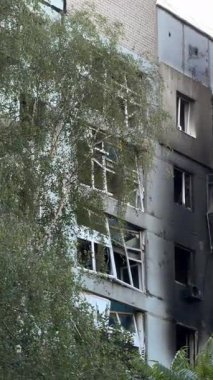 A damaged residential building with burnt-out balconies after shelling or fire. Broken windows and collapsed balcony structures are visible, the consequences of a conflict of damage.