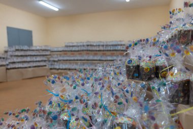 Açık filme sarılmış sayısız Paskalya pastası. Canlı detaylar görülebilir: beyaz krema, renkli serpinti. Bayramlık Paskalya hediyeleri ve Hıristiyan geleneği.