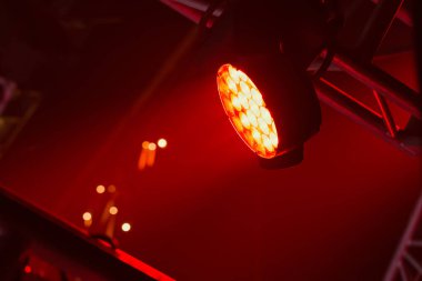Koyu kırmızı arka planda bir konserde konsolda sahne ışıkları