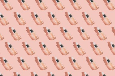 Yaratıcı desen şeffaf bir şişeden yapılmış. Hyaluronik asit serumuyla birlikte kolajenle ya da gölgeli pastel arka planda gerekli yağla. Doğal tedavi konsepti. Düz yatıyordu