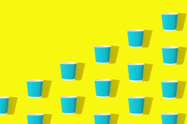 Parlak sarı arka planda ilerlemek için mavi kahve ya da çaydan yapılmış yaratıcı desen. Çevre dostu kavram. Düz yatıyordu. Üst görünüm