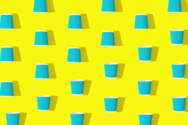 Parlak sarı arka planda ilerlemek için mavi kahve ya da çaydan yapılmış yaratıcı desen. Çevre dostu kavram. Düz yatıyordu. Üst görünüm