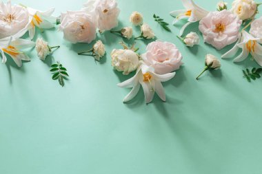 Pastel arkaplanda gül ve nilüfer çiçeklerinden oluşan yaratıcı bir yaz kompozisyonu. Güzel bir çiçek dekoru. Doğa konsepti. Üst Manzara. Düz yatıyordu