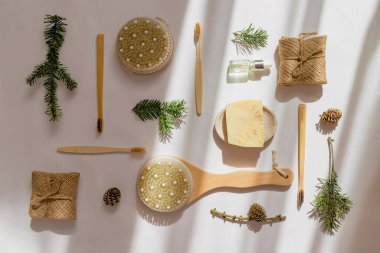 El yapımı sabun, serum şişesi, bambu diş fırçası, beyaz arka planda gölgeli doğal ahşap fırça. Plastiksiz, sıfır atık, sürdürülebilir yaşam tarzı konsepti.