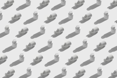 Eklenti, vitamin ve gölgeli güneş ışığı arkaplanındaki haplar için beyaz plastik şişelerden yapılmış minimal bir kalıp. Kapaklı bir paket seti var. Eczane ve ilaç konsepti