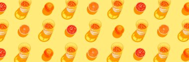 Dilimlenmiş greyfurt, kan portakalı ve sarı zemin üzerinde limonata ya da su bulunan camdan yapılmış yaratıcı afiş deseni. Yaz meyvesi ve içecek konsepti. Asgari düzeyde. Düz güneş ışığı yatıyordu. Üst görünüm