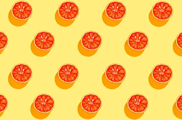 明るい黄色の背景に血のオレンジの半分で作られた創造的なパターン 夏の果物とビタミンの概念 ミニマルなスタイル トップ表示 — ストック写真