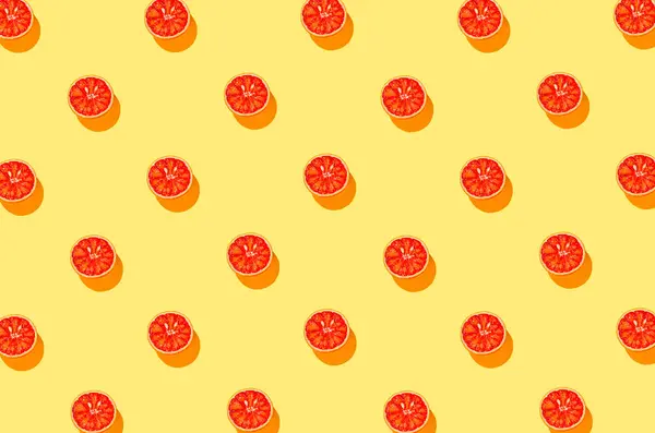 明るい黄色の背景に血のオレンジの半分で作られた創造的なバナーパターン 夏の果物とビタミンの概念 ミニマルなスタイル トップ表示 — ストック写真