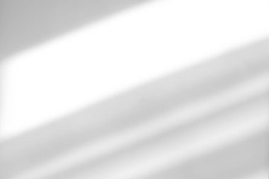 Beyaz arka plandaki bir pencereden gelen gölge ve güneş ışınlarından oluşan soyut bir zemin. Fotoğraf ve maketler için doğal ışık efektleri