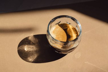 Bej arka planda gölgeli bir fincan kahve. Asgari biçim.