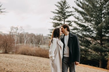 Bir sonbahar günü parkta yürüyen bir çift adam ve kadın..