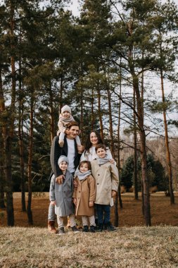 Big family in woods. Family spending time together on an autumn day. clipart