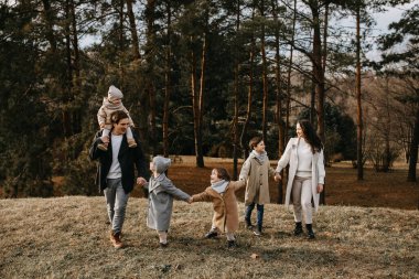 Ormanda gezen büyük bir aile. Aile, bir sonbahar gününde birlikte eğleniyor..