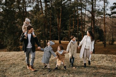 Ormanda gezen büyük bir aile. Aile, bir sonbahar gününde birlikte eğleniyor..