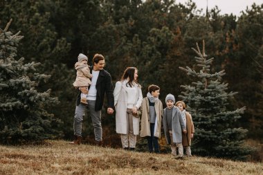 Altı kişilik büyük bir aile, ormanın içinde, büyükten küçüğe sıralanmış..