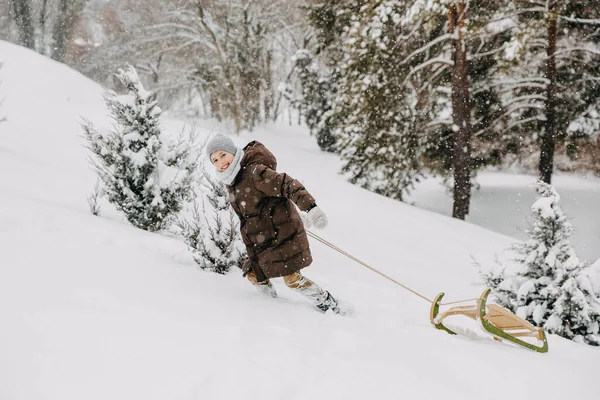 Pojke Drar Slädar Klättrar Kulle Snöig Vinterdag Bergen — Stockfoto