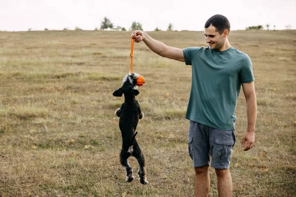 Homme Jouant Avec Chien Schnauzer Miniature Tenant Une Boule Orange — Photo