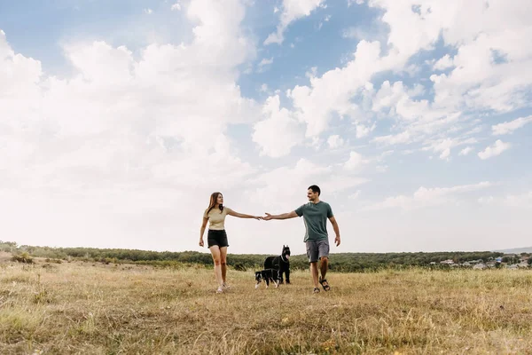 Ehepaar Geht Mit Zwei Hunden Auf Offenem Feld Spazieren — Stockfoto