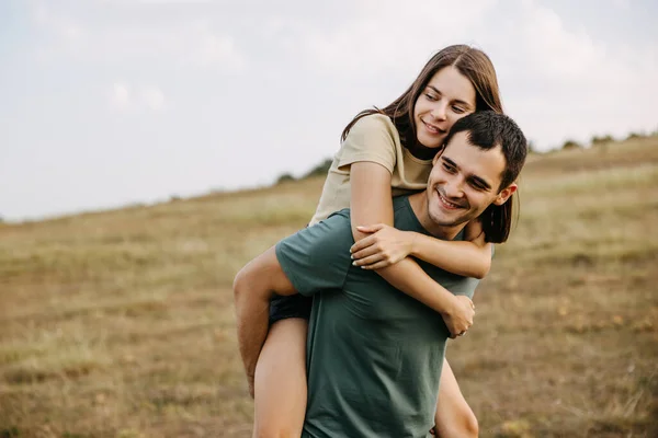野外で抱きかかえる若い男と女の幸せなカップル — ストック写真
