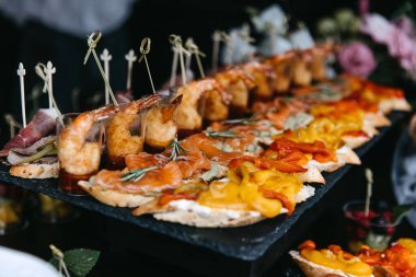 Different snacks at a party. Mini sandwiches on a fourchette table.