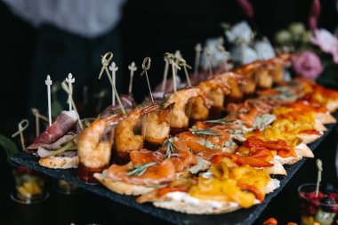 Different snacks at a party. Mini sandwiches on a fourchette table.