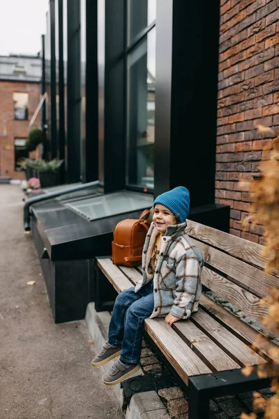 一个快乐的小男孩 坐在外面的木制长椅上 — 图库照片