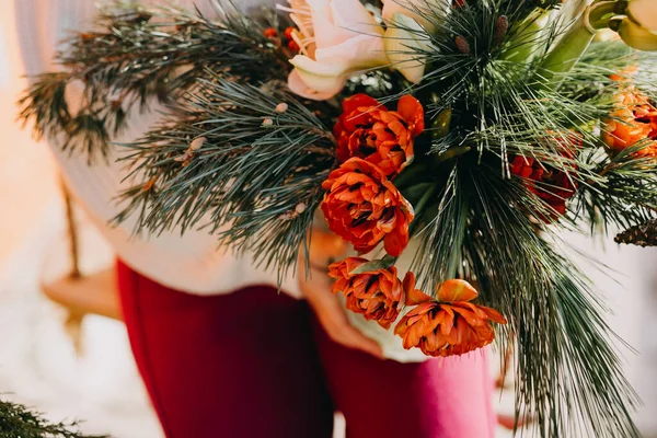 赤いチューリップ アイリックスベリー 松の枝とアマリリスの花で作られたクリスマスの花束を持っている女性 — ストック写真