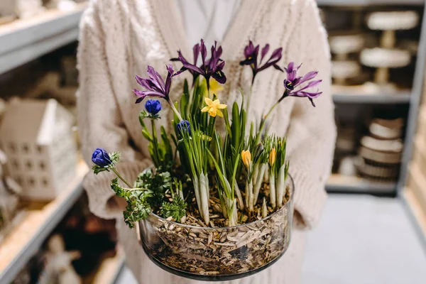 さまざまな春の花で作られた鍋に花の組成物を保持する女性 — ストック写真