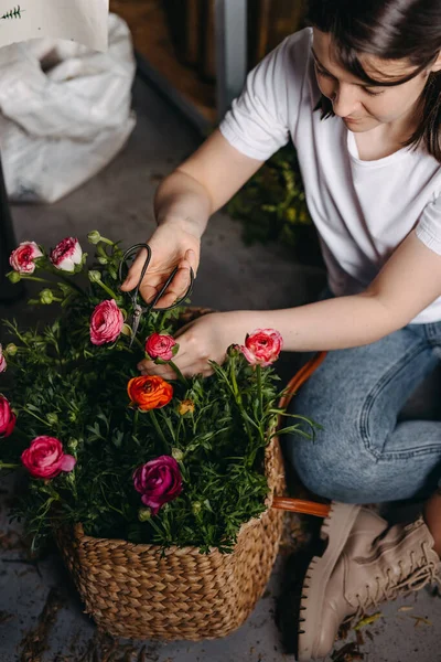 在花店工作的花匠用金属剪刀照料粉红兰花的妇女 — 图库照片