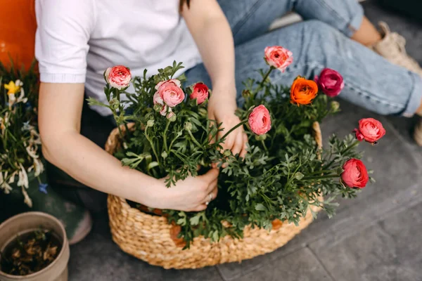 花屋の花屋で働いてる 女性は私たちの花の世話をし 大きなバスケットにそれらを配置 — ストック写真