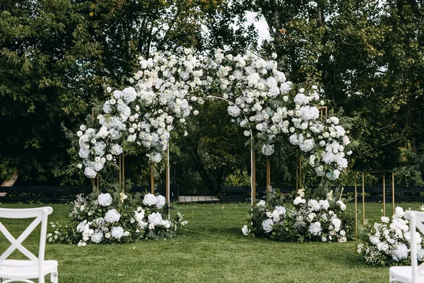 Svatební Obřad Obloukem Zdobeným Květinami Umístěnými Zelené Trávě Zahradní Místo — Stock fotografie