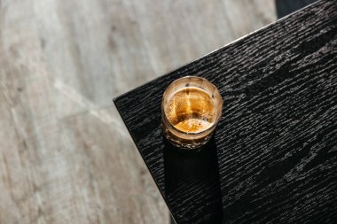 Tahta bir masada, güneş ışığında bir fincan kahve..