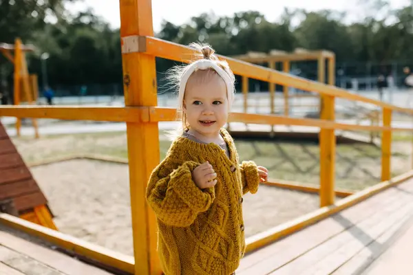 Mała Szczęśliwa Dziewczynka Zewnątrz Placu Zabaw Wiosenny Słoneczny Dzień Ubrana — Zdjęcie stockowe