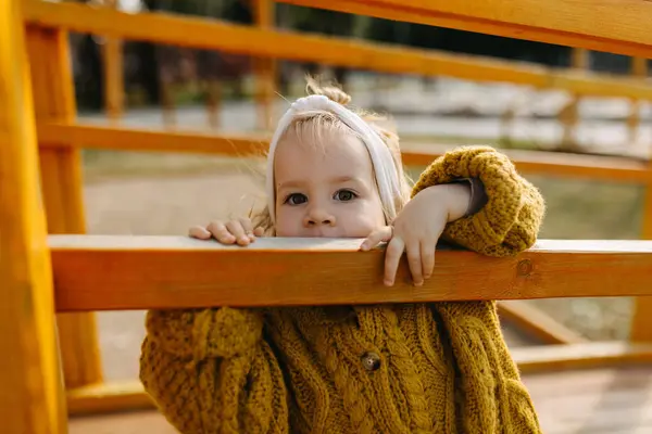 Mała Dziewczynka Wkładająca Usta Drewniany Płot Placu Zabaw Portret Bliska — Zdjęcie stockowe