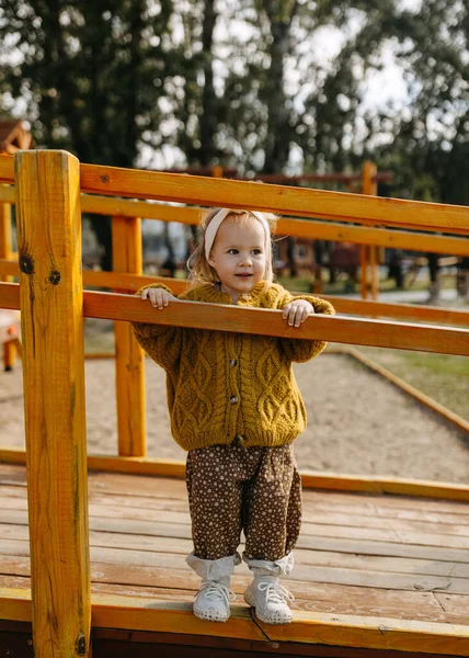 Mała Szczęśliwa Dziewczynka Placu Zabaw Ubrana Musztardowy Sweter Drutach — Zdjęcie stockowe