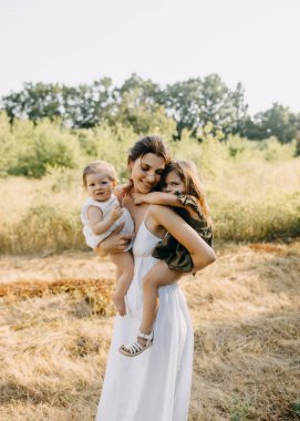 Anne, bir yaz günü iki kızıyla parkta oynuyordu. Onları kollarıyla tutuyordu..