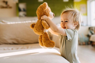 Oyuncak ayıyla neşeli bir bebek.