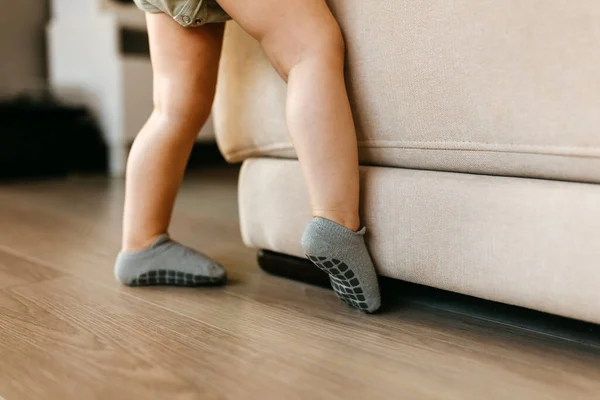 Bej Bir Kanepenin Yanında Gri Slip Çoraplı Bir Bebeğin Bacakları — Stok fotoğraf