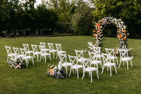 Zewnętrzny Zestaw Ślubny Kwiatowym Łukiem Ślubna Alejka Białymi Drewnianymi Krzesłami — Zdjęcie stockowe