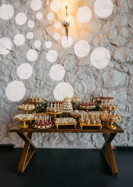 Lavish Dessert Table Set Stone Wall Golden Stands Wooden Table Royalty Free Stock Images