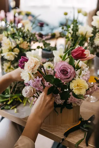 花のワークショップテーブルにさまざまな花束を配置する手のクローズアップビュー ロイヤリティフリーのストック写真