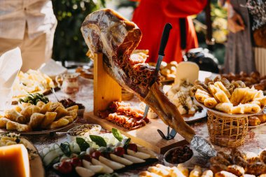 Pişmiş jambon, peynir, hamur işi, zeytin ve kırsal bir masada aperatiflerle servis edilen meze..