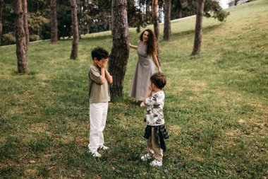 Anneleri yakınlarda saklanırken iki çocuk ormanda saklambaç oynuyor..
