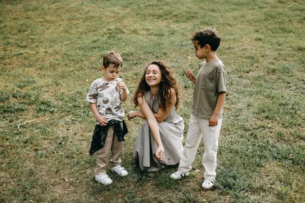 Anne ve oğulları otlakta karahindiba üflüyorlar..