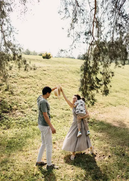 Mutlu aile dansı ve ağaçların altındaki parkta oynamak.