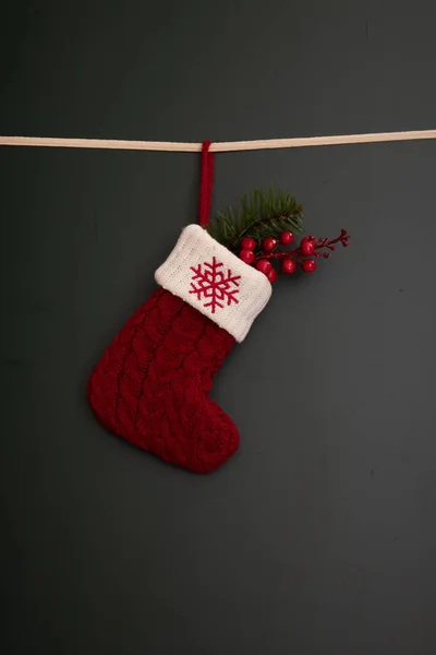 Stock image Red Sock on Green Background , with red berried Green fir and red glitter star