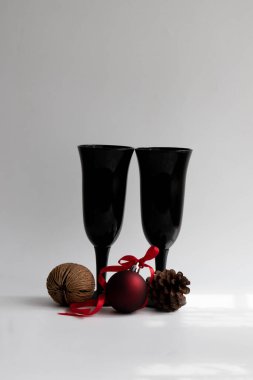 Bir çift Black Vine Glass, Red Christmas Asma Balosu, Pine Cone ve Nut on White Background