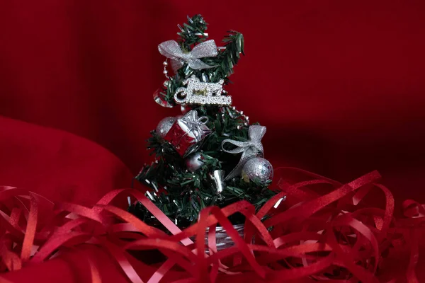 Árvore Natal Pequena Decorada Com Ornamentos Prata Fundo Vermelho — Fotografia de Stock