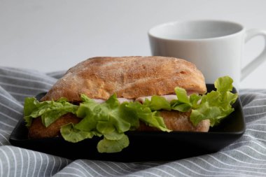 Beyaz arka planda sağlıklı sandviç, jambon ve peynirli ciabatta ekmeği.